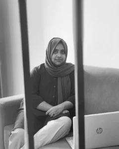 A young woman sitting on a sofa with a laptop, embodying the essence of the Best Freelance Digital Marketing Strategist in Calicut, Kerala.